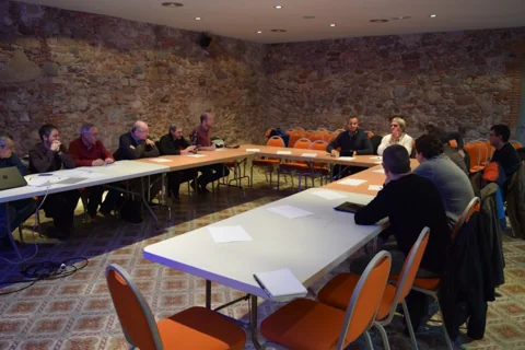 Vista general d’una de les primeres trobades, amb els participants al voltant de les taules